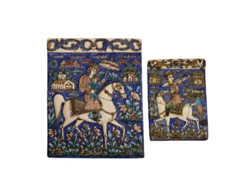 TWO QAJAR POLYCHROME MOULDED TILES 19TH CENTURY The larger tile decorated with a figure carrying a child and a parasol whilst