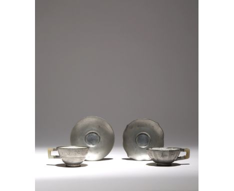 TWO CHINESE INSCRIBED PEWTER-ENCASED AND ENAMELLED YIXING TEACUPS AND SAUCERS QING DYNASTY One with a foliate rim, the other 