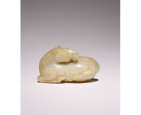 A CHINESE CELADON JADE CARVING OF A HORSE 17TH CENTURY OR LATER The recumbent horse turned looking over its back, with its tw