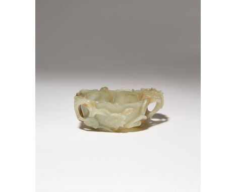 A CHINESE CELADON JADE BRUSH WASHER MING DYNASTY Formed as a flowerhead with a raised boss to the well, carved in high relief