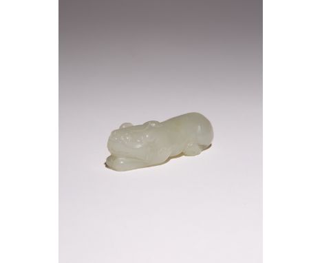 A CHINESE PALE CELADON JADE 'MYTHICAL BEAST' PENDANT QING DYNASTY The dog-like creature depicted in a recumbent pose with its