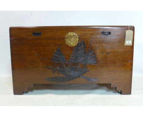 A 20th century Chinese camphor wood trunk, carved with ships, raised on castors, H.58 W.101 D.55cm 