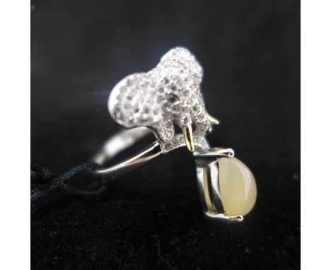 A sterling silver 3-piece jewellery suite in the form of elephant heads set with white sapphires and suspended by opals. Ring