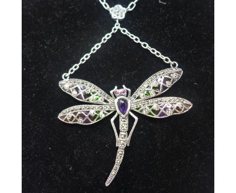 A sterling silver dragonfly necklace set with an amethyst cabochon body, ruby eyes, marcasites and enamelled wings in green a