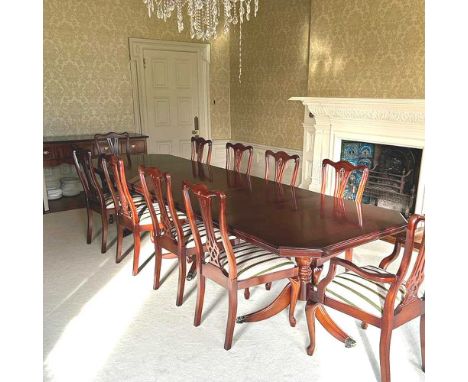 A reproduction mahogany triple pillar dining table, with two additional leaves, together with a set of ten dining chairs, to 