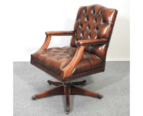 A brown leather button back swivel desk chair