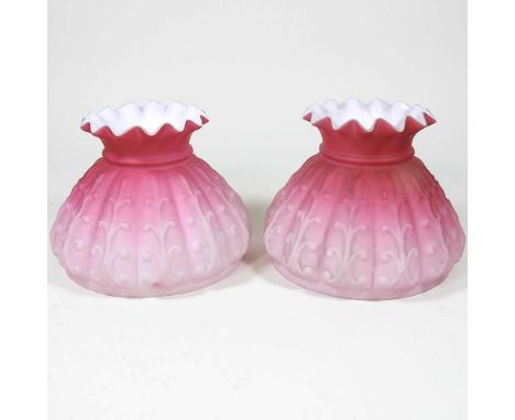 A pair of Burmese pink glass peg oil lamp shades, 12cm high (2)Both are dirty with light surface marks. Some fine chips aroun