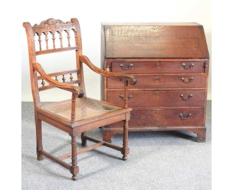 A George III oak bureau, on bracket feet, 91cm wide, together with an early 20th century French cane seated open armchair (2)