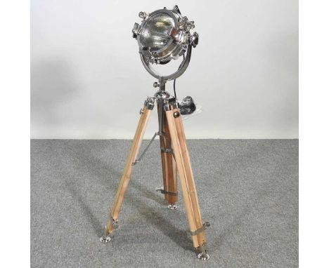 A standard lamp, in the form of a search light, on a teak adjustable base