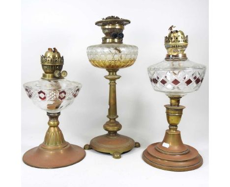 An early 20th century oil lamp, with a cut glass reservoir, together with two others (3)
