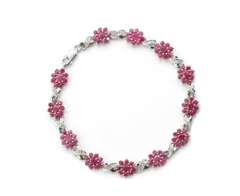 A silver ruby and diamond bracelet, with fracture filled ruby set clusters, joined by eight cut diamond set cross links, to s