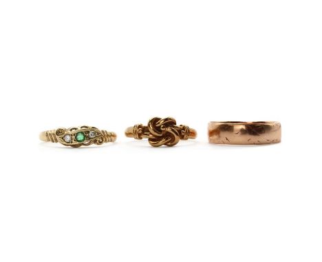 Three 9ct gold rings, comprising an emerald and diamond three stone ring, Sheffield 1995, a knot ring, London 1966, and a wed