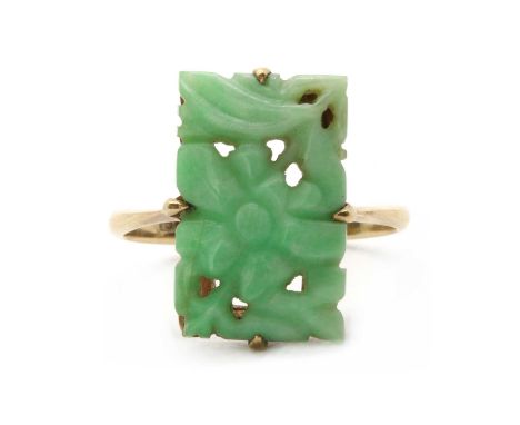 A gold jade ring, a carved, pierced rectangular jadeite jade plaque, claw set, to tapered shoulders and a 'D' section shank, 