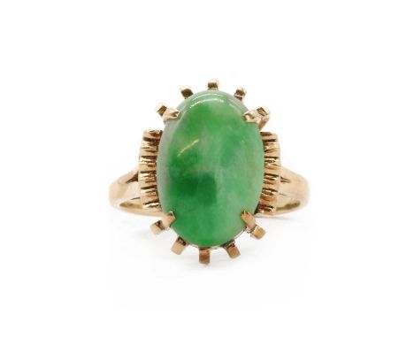 A gold single stone nephrite jade ring, an oval nephrite jade cabochon, claw set, to split shoulders and a plain shank, teste