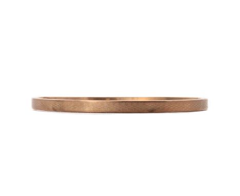 A 9ct gold hollow flat section upper arm bangle, by Henry Griffith &amp; Sons, with machine engraved decoration, Chester 1924