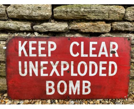 A rectangular warning enamel sign bearing the words 'Keep Clear Unexploded Bomb', 27 x 14".