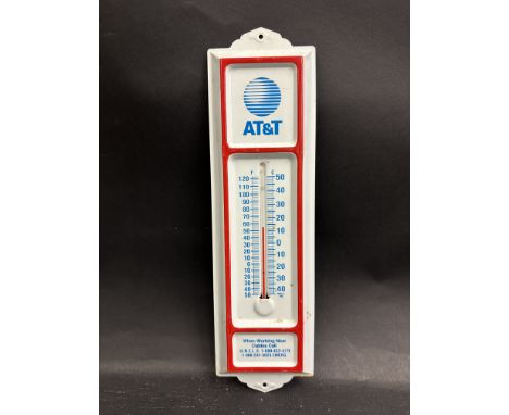 A small tin fronted thermometer bearing advertising for A.T.&amp; T.