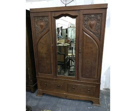 Early 20th century oak wardrobe, the central mirrored section flanked by cupboard doors, on base of two drawers, ogee bracket