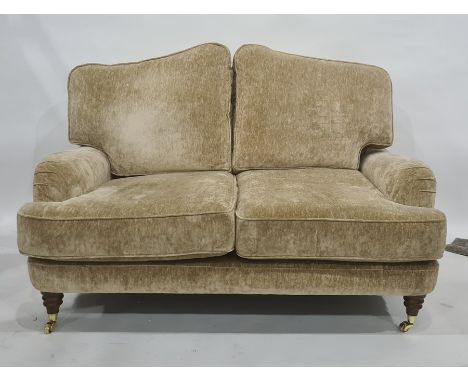 Two-seat Laura Ashley sofa in pale gold coloured upholstery, turned supports to brass caps and castors Condition ReportThe di