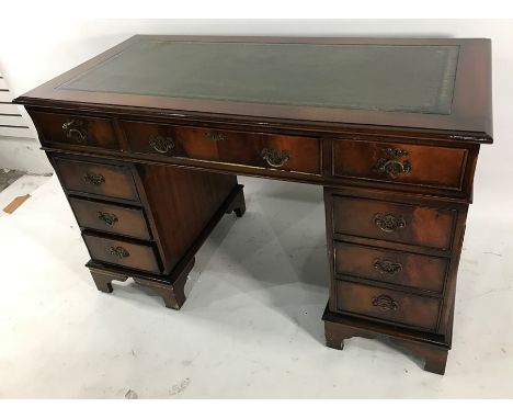 20th century pedestal desk with green leather inset top above nine assorted drawers, on bracket feet, 120cm wide