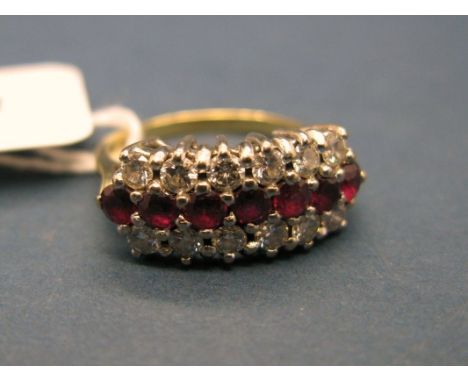 An 18ct Gold Ruby and Diamond Set Dress Ring, of three row design, claw set throughout. *H. Samuel Insurance Valuation of £2,