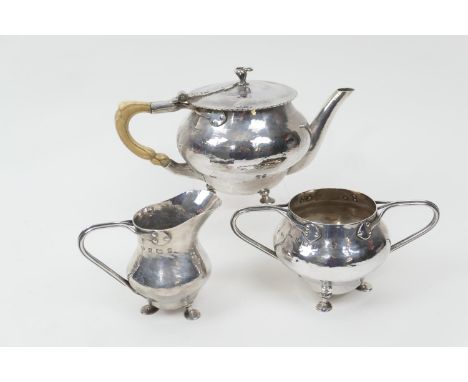 Arts and Crafts silver composite three piece tea service, the lidded hammered teapot by William Hutton & Sons, London 1905, w