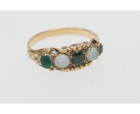 Emerald and opal five stone ring, having three small cushion cut emeralds dispersed with two cabochon opals, in scrolled claw