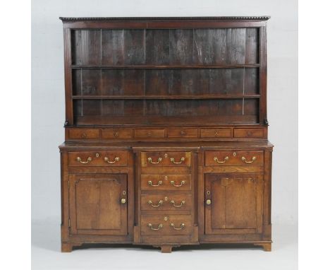 George III oak dresser and plate rack, circa 1760-80, the boarded rack with dentil cornice and two shelves over a gallery of 