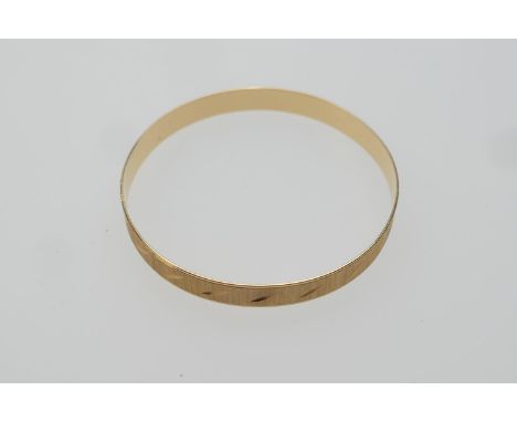 Yellow gold bangle, with a matted and chiselled leaf finish, continental marks, 6.5cm diameter, weight approx. 15.5g (Please 