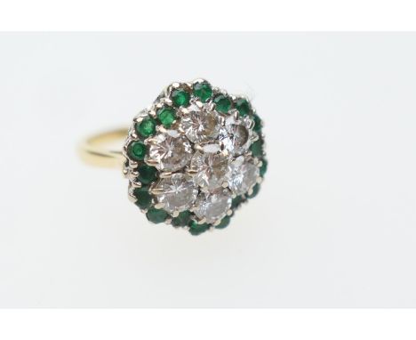 Unusual diamond and emerald cluster ring, centred with seven round cut diamonds totalling approx. 1.8cts, bordered with small