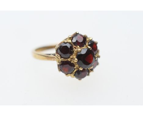 Garnet cluster ring in 9ct gold, set with seven round cut garnets in a coronet style setting, size O, gross weight approx. 3.