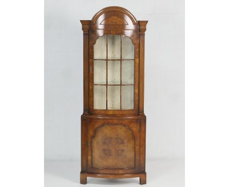 Quality walnut bow front freestanding corner display cabinet, in Queen Anne style, the top glazed section beneath an arched c