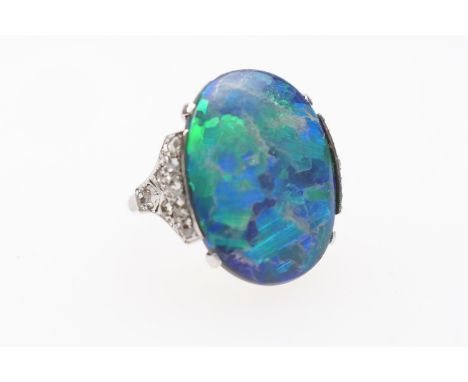 Black opal and diamond ring, having a cabochon opal doublet of approx. 20mm x 16mm, the shoulders set with rose cut diamonds 