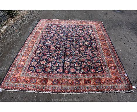 An Isphahan Carpet, Central Persia; the mid indigo field having all over pattern of leaves and flower heads framed by a madde