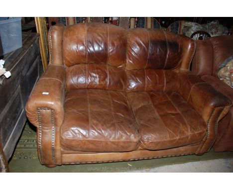 A good quality brown Leather two seater Sofa, having brass button nailed upholstery, worn but good condition