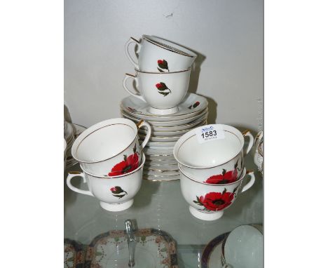 A part Teaset with poppy design comprising six cups, saucers and tea places