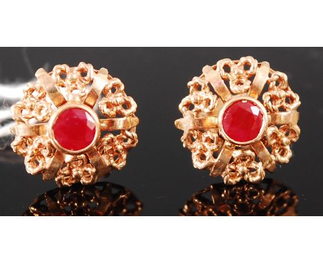 A pair of modern 9ct gold and ruby set ear studs, each arranged as a flower head, 2.8g, dia. 1.4cm