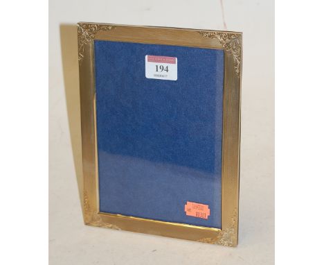 A George V silver gilt easel photograph frame, of rectangular form, having engine turned decoration and acanthus leaf engrave