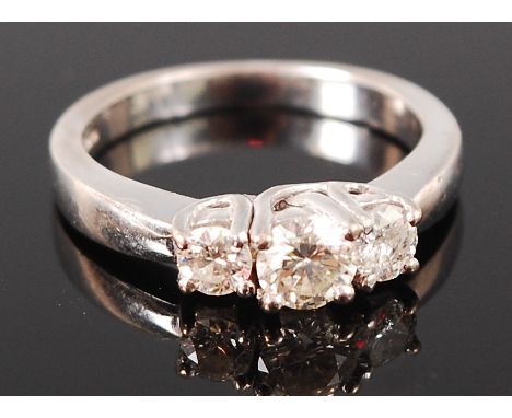 An 18ct white gold diamond three stone ring, the centre stone weighing 0.35ct, the outer stones weighing 0.16 and 0.14ct, siz