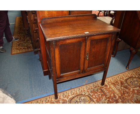 A 1940's Oak Cabinet, having upstand back with ball moulding, rectangular moulded edge top over a pair of opposing single mou