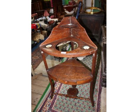 A Georgian Oak bow fronted Washstand, shaped gallery top with rear shelf, the top having three holes for wash bowl and two po