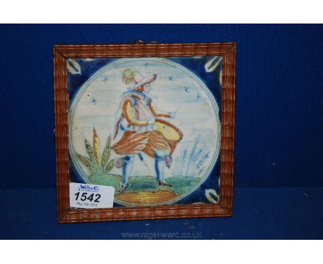 An antique Delft polychrome Tile painted with a soldier within a blue roundel, framed.