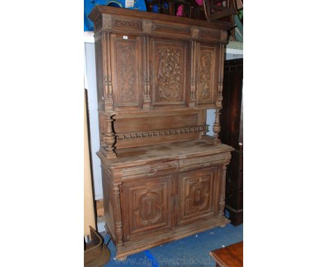 A French Oak Dresser, having moulded cornice over panelled frieze with corbels, central single panel door with applied mouldi