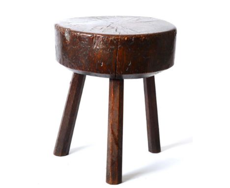 A 19th Century Primitive Oak Stool or Chopping Block, of trunk form raised on three chamfered legs, 38cm by 41cm