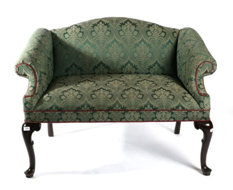 A George III Style Camel Back Bedroom Sofa, upholstered in green floral fabric with rounded arm supports and overstuffed seat