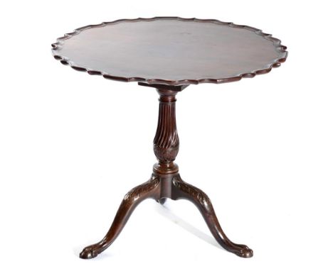 A Carved Mahogany Fliptop Tripod Table, the associated moulded top above a birdcage platform raised on a fluted and acanthus 