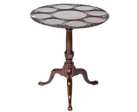 A Carved Mahogany Fliptop Tripod Table, the circular top made up of a central panel surrounded by eight smaller moulded panel