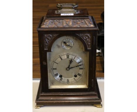 A Mahogany Quarter Striking Mantel Clock, circa 1910, pediment with carrying handle and a carved border, silvered dial with a