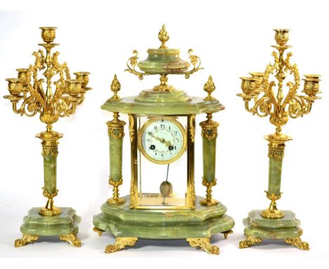 A Green Onyx Striking Mantel Clock Garniture, early 20th century, four glass gilt metal mounted case surmounted by an urn fin