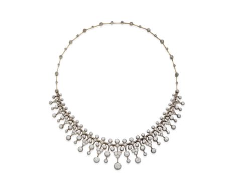 DIAMOND FRINGE NECKLACE, CIRCA 1890The articulated chain suspending a graduated knifewire fringe of collet-set old brilliant 
